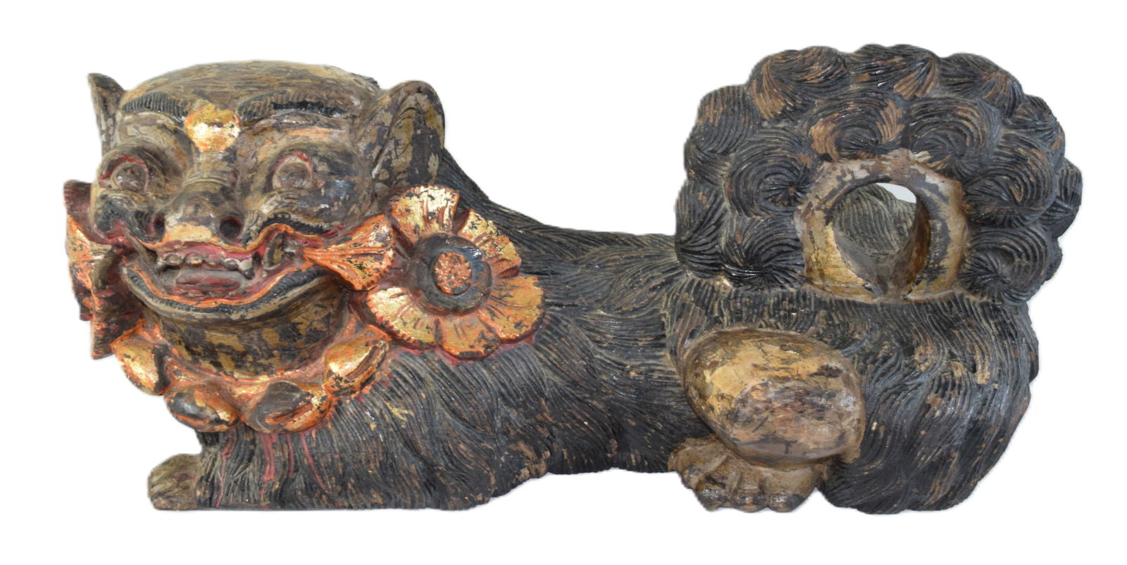 Large Wooden Reclining Foo Dog: A large well carved, reclining wooden Foo Dog with gilt wood elements. Dimensions: 11" H x 25" L x 10" W
