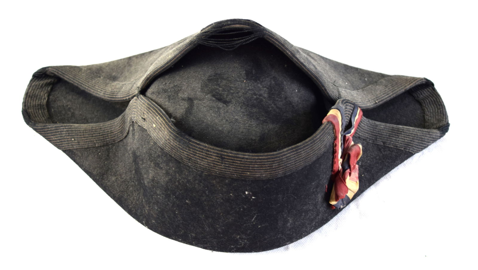 Bicorn Hat: Early 19th century bicorn hat with red, white and blue ribbon. No Label