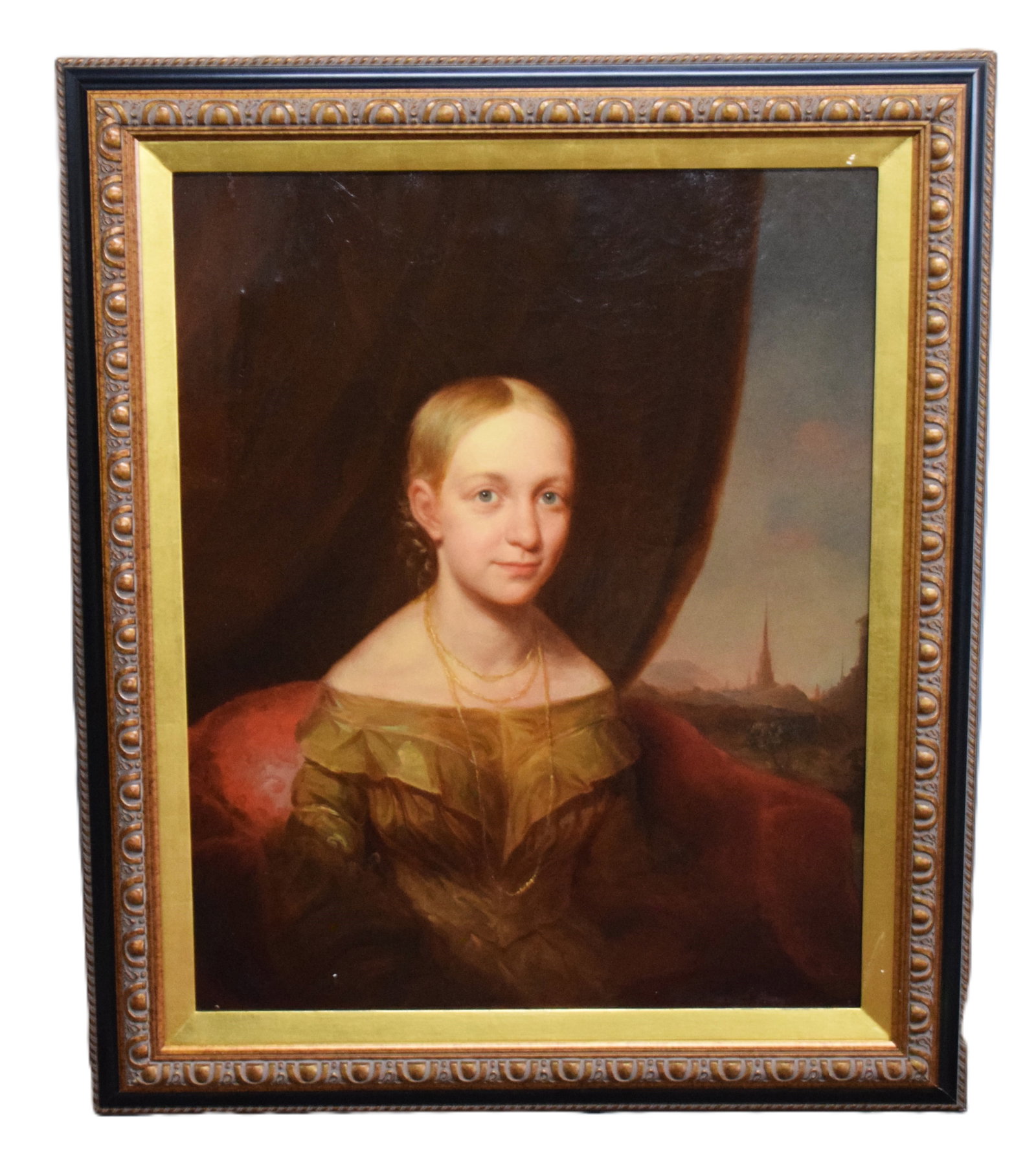 19th Century Portrait Of A Young Lady: Framed 19th Century portrait of a young lady in a brown dress and gold necklaces, seated on a red chair, overlooking a cityscape. There is handwriting on the back of this New York canvas which may be