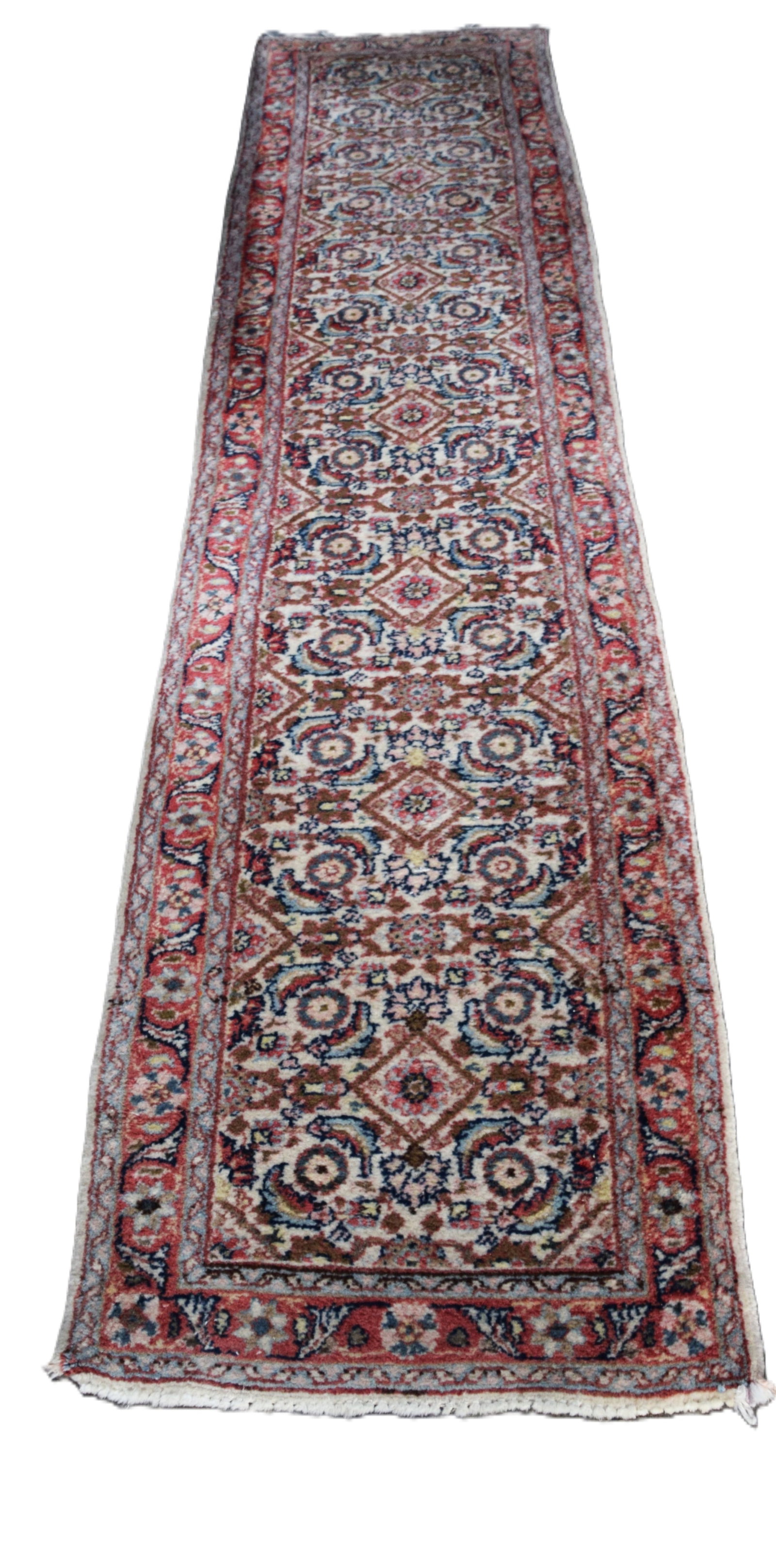 Oriental Runner: Good oriental runner, multi-design with diamond and circle patterns, flowers with red and ivory background, with label on back 100% wool pile from Iran. From a New London NH home. Dimensions: 2'4" x