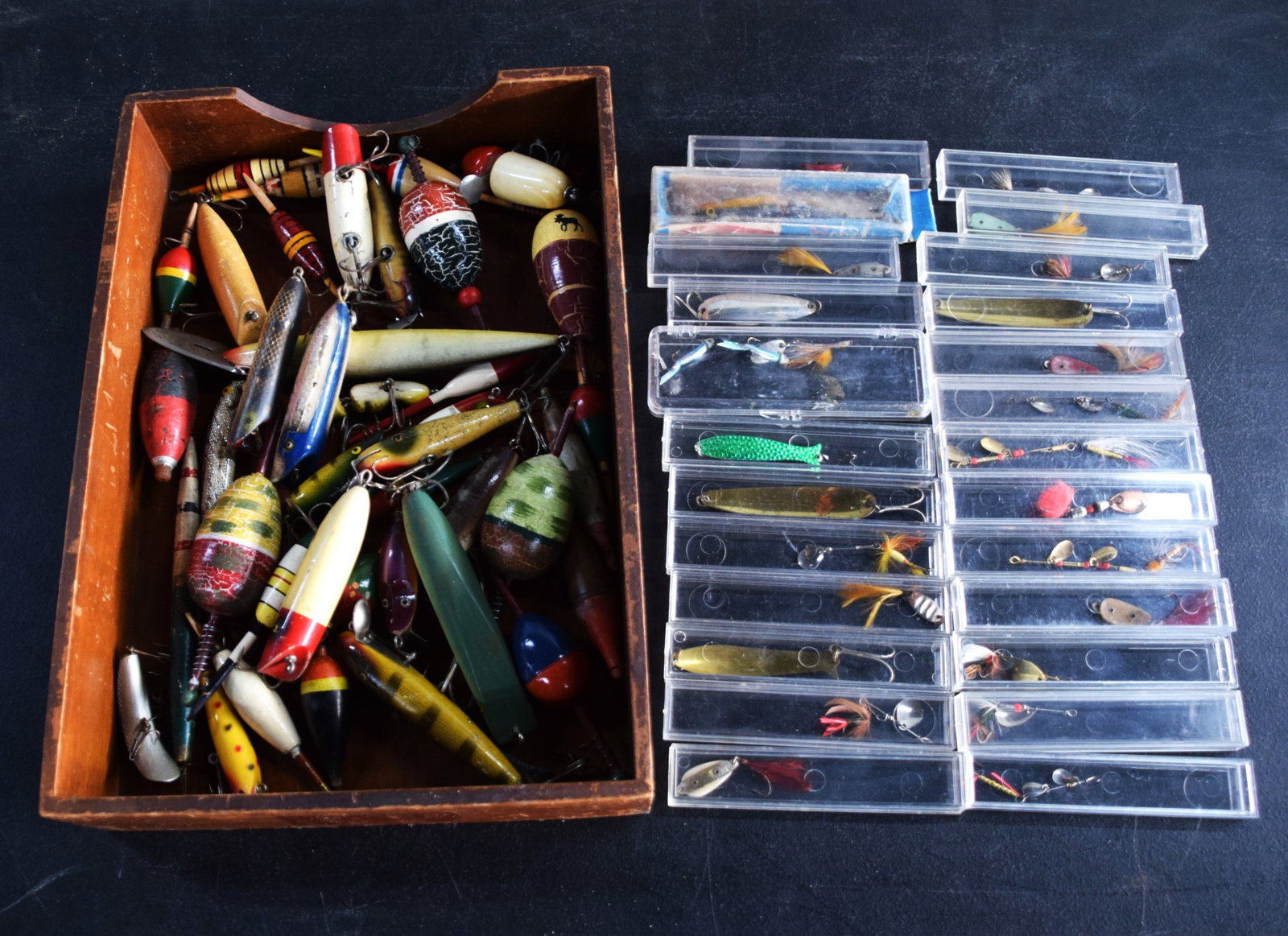 Large Lot Of Fishing Lures: Approximately 30 wooded fishing lures along with 23 plastic encased lures, flies and bait items.
