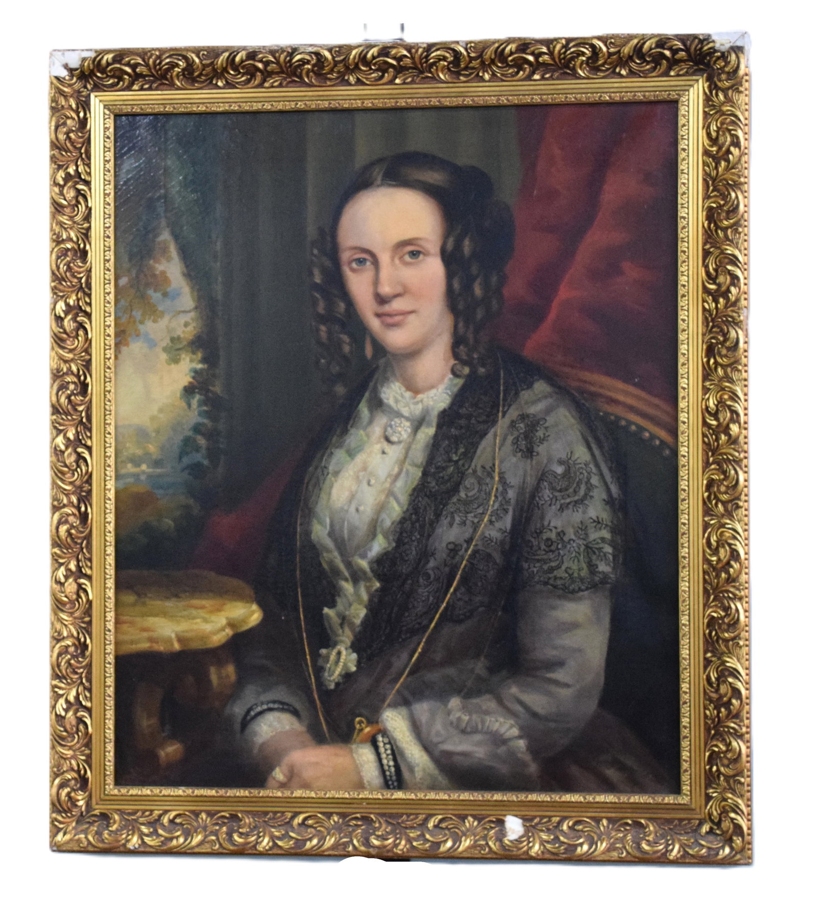 Mid 19th Century Oil Portrait Of A Lady: Extremely well done mid 19th century oil portrait of an elegant and attractive lady, wearing a fancy blouse and a lace cover-up, bedecked with jewelry, sitting in her parlor. The mid-19th century was