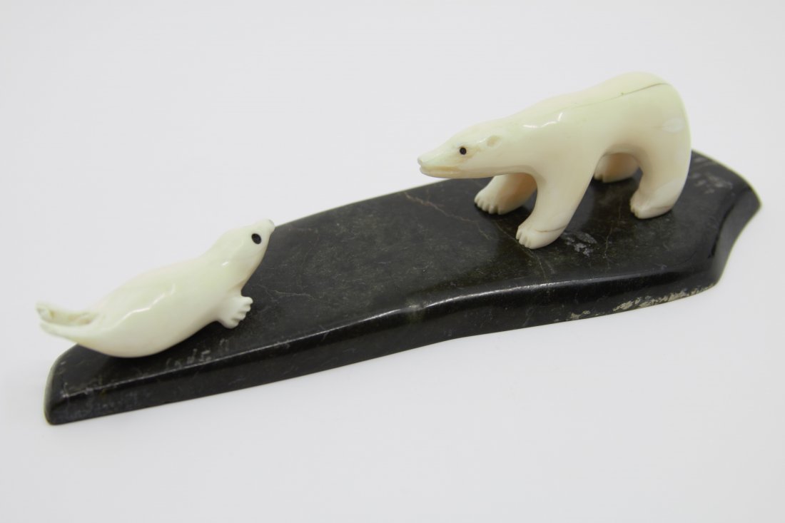 Panigayak, Isaac , 1950-, Polar bear hunting a seal: Sculpture en pierre et os signÃ©e en dessous Stone and bone sculpture, signed underneath 2" x 7" x 2 1/2" 5.08 x 17.78 x 6.35 cm