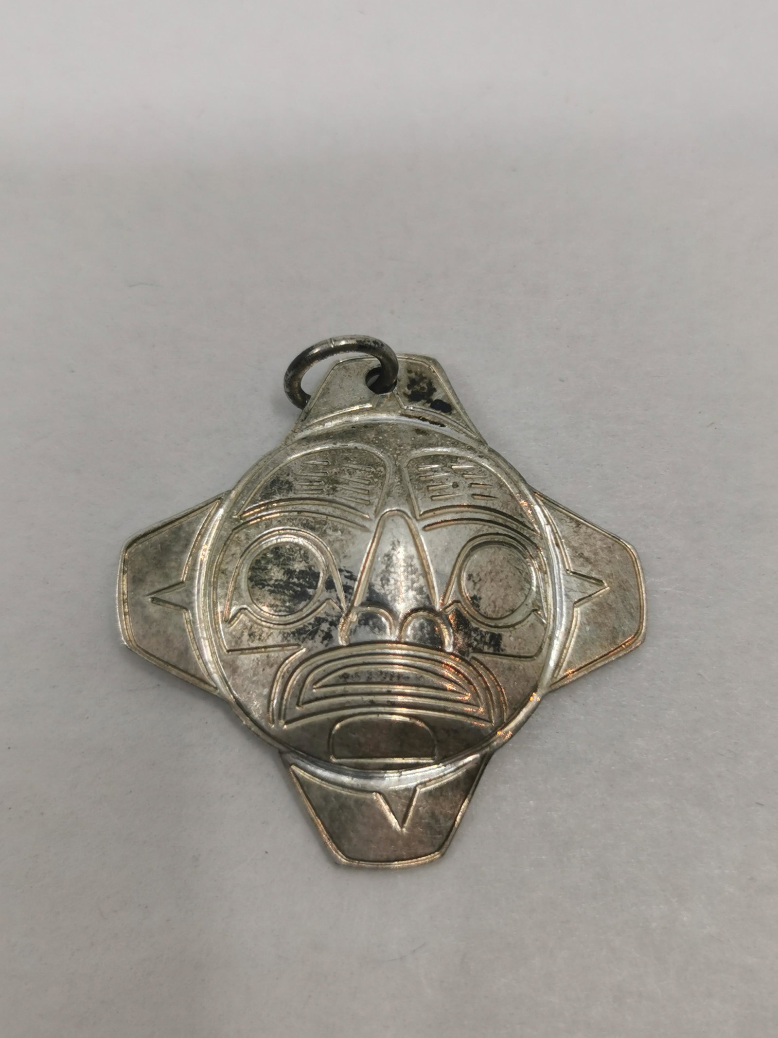 Haida, John Lancaster, Sterling silver Sun Pendant: Artist: John Lancaster (1960- ) Canada, BC Title: sterling silver Sun pendant Description (FR): Pendentif en argent sterling, representant un soleil mythique, signe au dos JL Description (ENG): Sterli