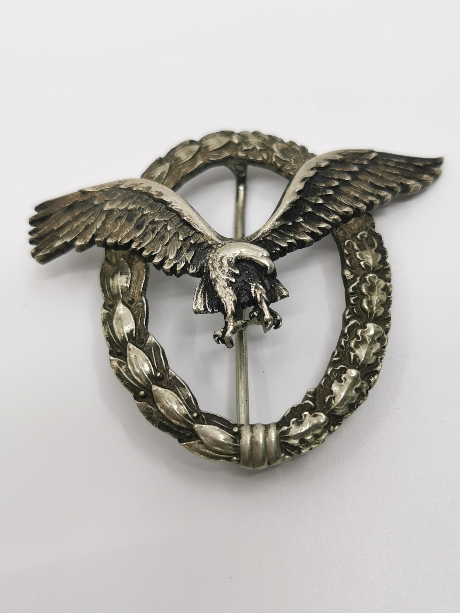German WWII Luftwaffe Pilot Badge: Title: German WWII Luftwaffe Pilot Badge Description (FR): Insigne de Pilot de la Luftwaffe allemande de la seconde guerre mondial, swastika Brise, marque au dos : C.E. Juncker Berlin SW Description (