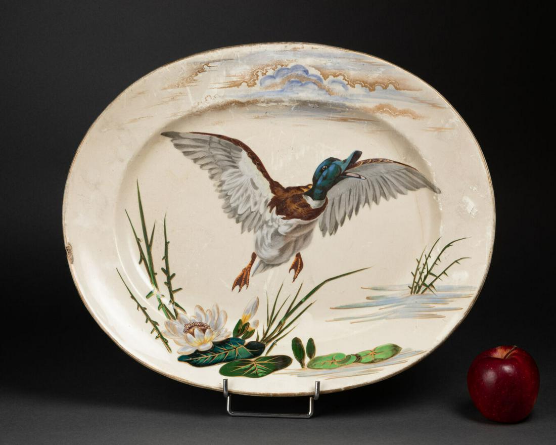 Keller & GuÃ©rin Ã LunÃ©ville: PLAT ovale Ã dÃ©cor d'un canard prenant son envole FaÃ¯ence Ã©maillÃ©e polychrome H. 41,5 cm. L. 34 cm Fissure, un Ã©clat