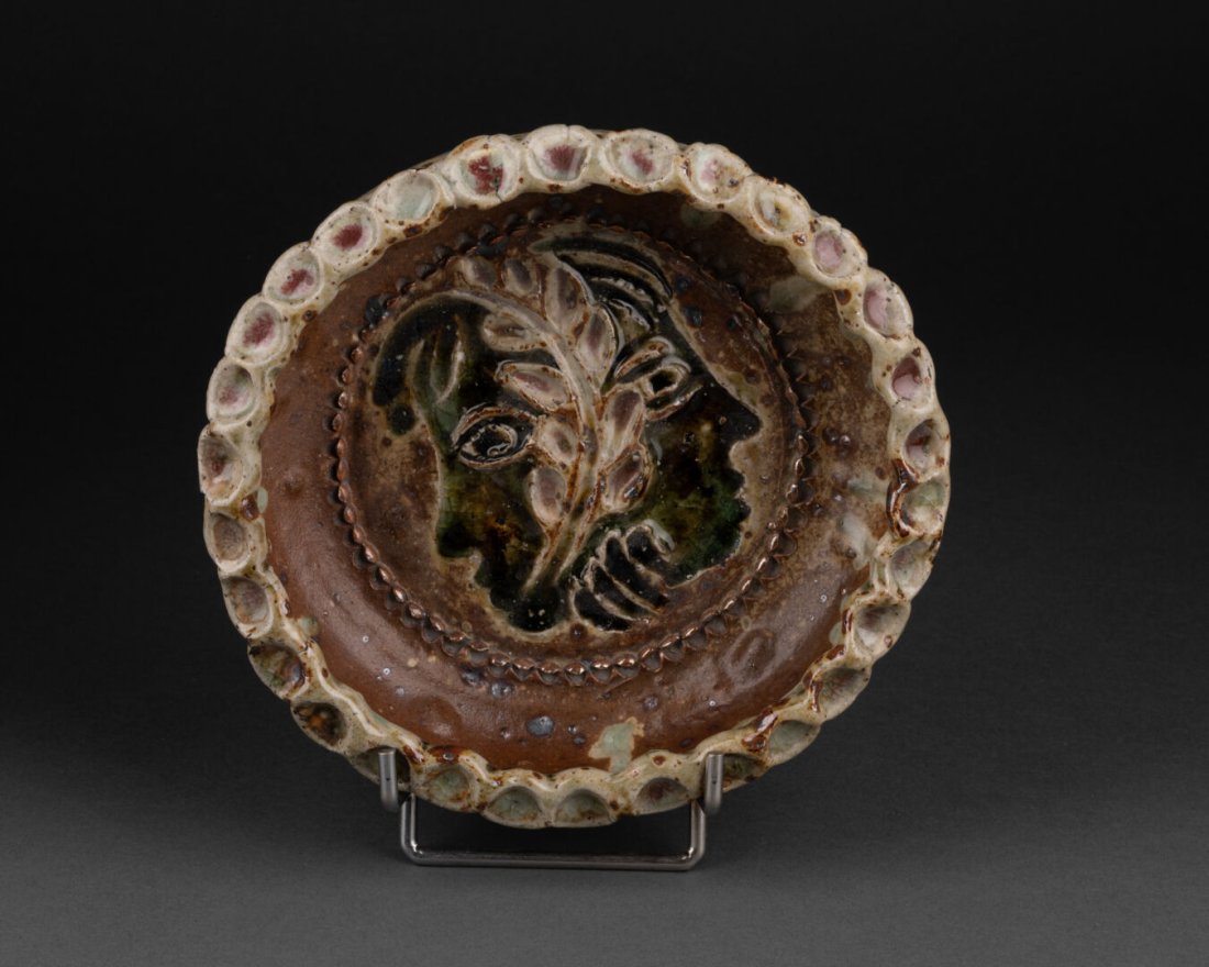 Jean LERAT (1913-1992) à la Borne: VIDE-POCHE Ã dÃ©cor de deux visages sÃ©parÃ©s d'une feuille de laurier La lÃ¨vre Ã motifs de pastilles CÃ©ramique Ã©maillÃ©e SignÃ© et porte la rÃ©fÃ©rence 149 H. 6 cm - D. 2