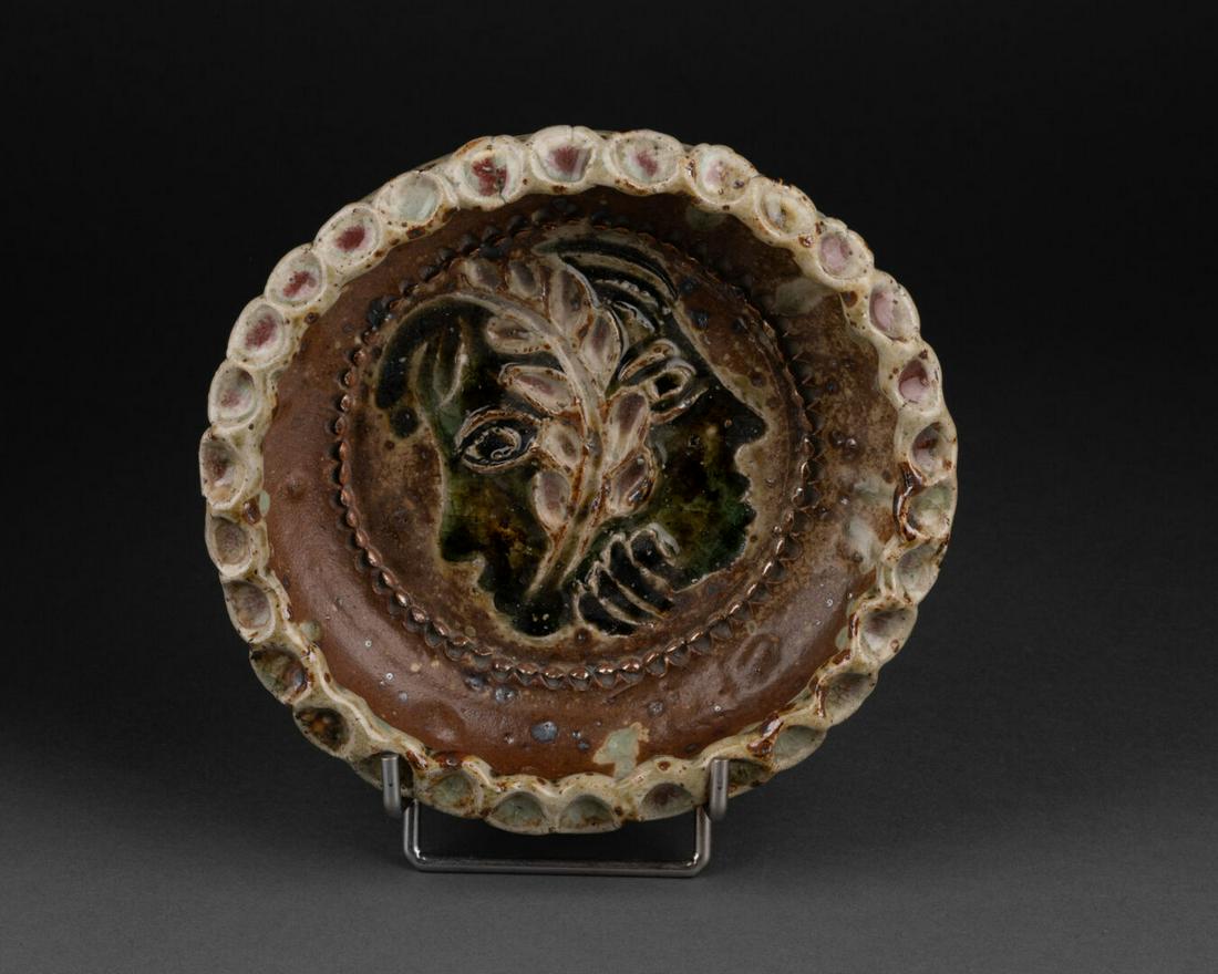 Jean LERAT (1913-1992) à la Borne: VIDE-POCHE à décor de deux visages séparés d'une feuille de laurier La lèvre à motifs de pastilles Céramique émaillée Signé et porte la réfé