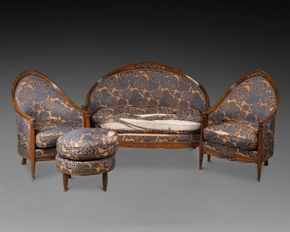 Paul FOLLOT (1877-1941), attribué à: SALON comprenant un CANAPE, deux BERGERE ,deux CHAISES et un REPOSE-PIEDS Le dossier à décor de fleurs stylisées, les supports d'accotoirs cannelés en rappel sur le pied antér