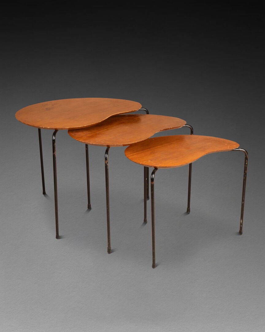 Dans le goût de Jacques HITIER (1917-1999): Trois TABLES gigognes, c. 1950 Le plateau de forme rognon Bois lamellé-collé, piétement tripode en métal tubulaire laqué noir H. 49,5 cm - L. 61,5 cm (pour la plus grande) Usu