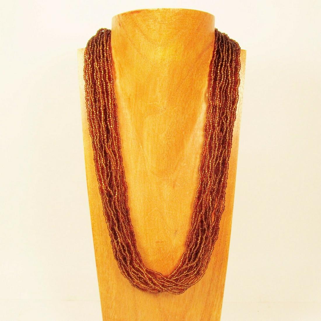 Multi Strand Amber Dark Gold Handmade Seed Bead Statement Necklace: Beautifully Handcrafted by highly skilled artisans. Statement Necklace, 20 strands of beads! Can slip over head to wear or use beaded clasp. Amber Color, like a root beer color, very neutral, works wi