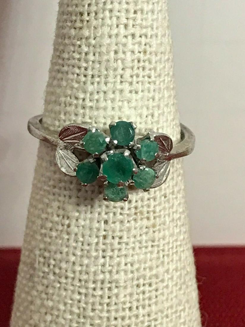 Vintage Ring Sterling Silver Emerald Flower in Leaf 7.5: Vintage emerald gemstone flower ring in a sterling silver leaf setting. The band of this dainty ring is slightly out of round, although completely wearable. There's one elevated emerald that's about 4