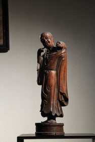 A clear boxwood carved Liu Hai playing with a golden toad ornament