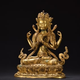 A bronze gilded four armed statue of Guanyin
