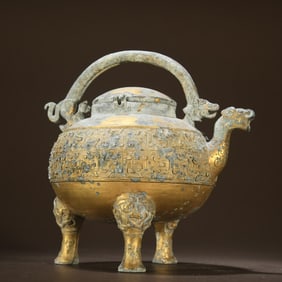 A copper gilded tiger headed coiled dragon patterned teapot with a lifting beam