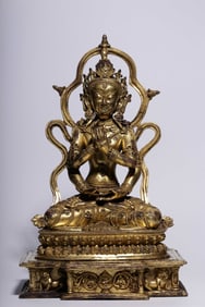 A Qing Dynasty bronze gilt four-armed Guanyin seated statue