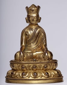 A seated statue of a gilt Karmapa lama from the Qing Dynasty