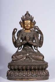 A Qing Dynasty bronze gilt silver depiction of a four-armed Guanyin seated statue