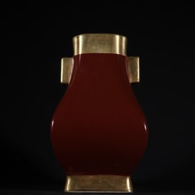 A Qing Dynasty Qianlong Ji red glazed gold-filled ear bottle