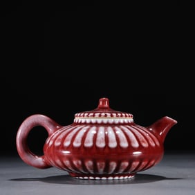 A piece of clear red glazed melon ribbed teapot