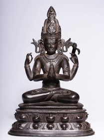 A Qing Dynasty four-armed bronze statue of Guanyin