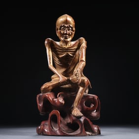 A Qing boxwood painted gold skinny arhat ornament