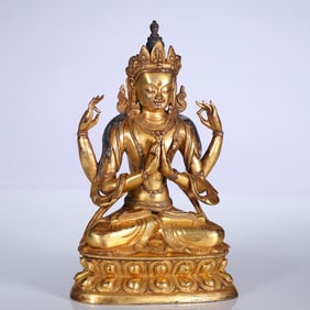 A bronze gilt four-armed statue of a bodhisattva