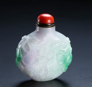 A piece of Qing Dynasty Fei Cui Fu in front of the cigarette bottle