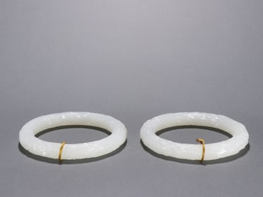 A pair of Qing Dynasty Hetian jade carved cloud dragon pattern bracelets