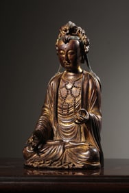 A clear sandalwood lacquered gold carved statue of Guanyin