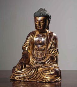 A seated statue of Shakyamuni in sandalwood lacquered gold