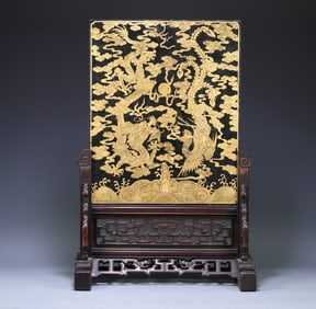 A Qing Dynasty Hetian jasper depicts a golden dragon and phoenix in an auspicious landscape