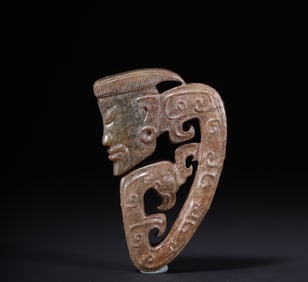 A piece of green jade with a human face pattern