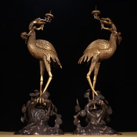 A pair of Qing bronze gilt crane title longevity peach candlesticks