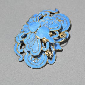 A piece of silver gilt dotted emerald butterfly hat flower