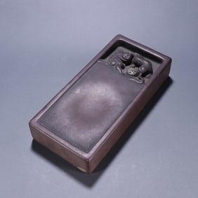 A stone carving of a lion playing ball inkstone