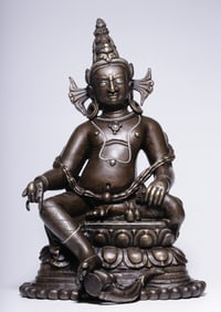 A Qing Dynasty alloy copper pala style yellow God of Wealth seated statue