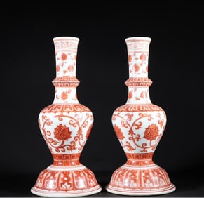 A pair of sweet white glazed vanadium red entwined lotus pattern candlesticks from the Yongxuan