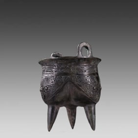 A bronze vessel with a three-legged animal face pattern ding