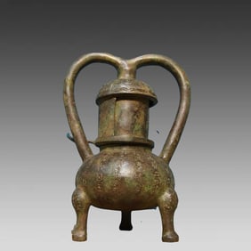 A bronze double-tube lamp with an inscription on the animal's foot