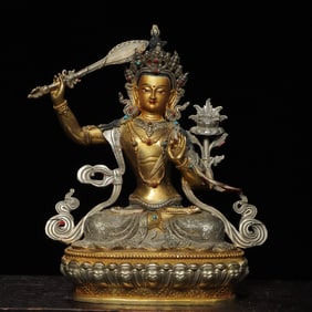 A bronze statue of Manjushri Buddha painted in silver