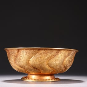 A bronze gilt bowl with a pattern of flowers and birds