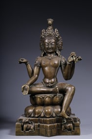 A Qing Dynasty alloy copper inlaid with silver, three sides, four arms, free Guanyin seated statue