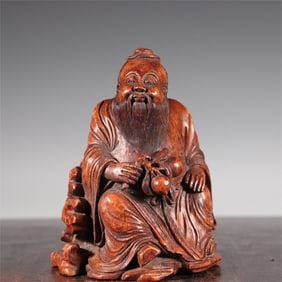 A Qing Dynasty bamboo carving of Oriental Shuo picking peach seated statue