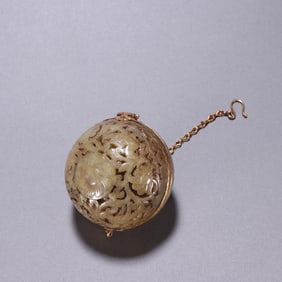 A piece of Hetian jade wrapped in gold and carved flower and bird pattern incense balls from the