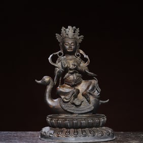 A bronze statue of a Buddha statue of a duck on a gold mount