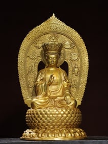 A bronze gilt backlit statue of Shakyamuni Buddha