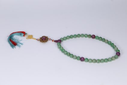 A piece of old jade from the Qing Dynasty is held by thirty-six sons