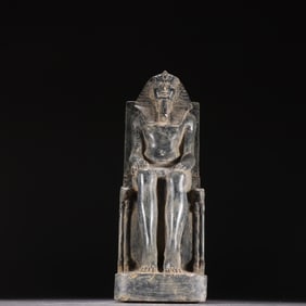 A fine black stone seated statue of Thutmose III with nine bows