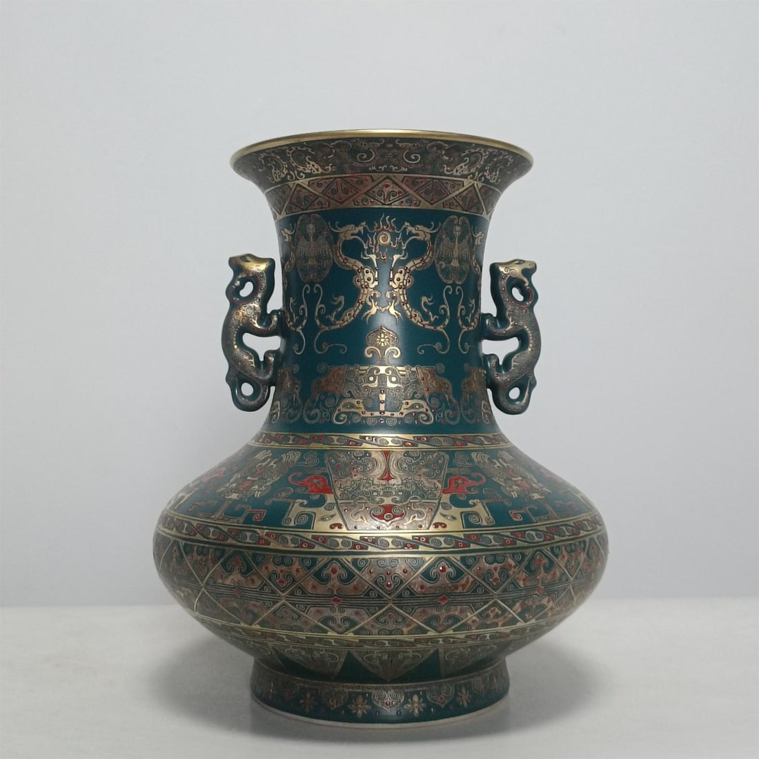 A Qing Dynasty Qianlong peacock green glaze gilded silver dragon and phoenix elephant gluttonous: Qing Qianlong model peacock green glaze gilded silver dragon and phoenix elephant gluttonous pattern amphora cup Size:H:30.3cm W:24cm (The Dimensions Of All Batches Are Manually Measured.If You Need M